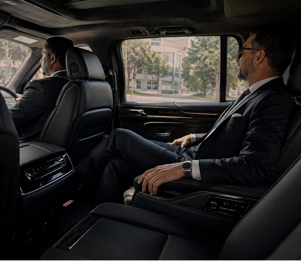Ejecutivo viajando de forma segura en el interior de una camioneta blindada con chofer profesional.